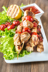 Grilled chicken skewers on the white plate