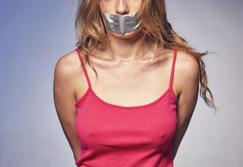 Young woman with his mouth glued with tape.