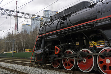 Fototapeta na wymiar active retro steam locomotive on the shunting tracks of the modern railway station