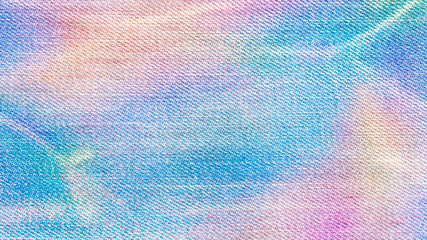 Holographic or rainbow colored jeans textile. Texture background jeans surface.