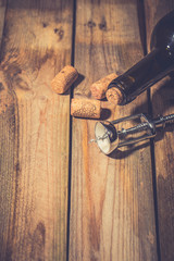 Wine corks and corkscrew on wooden table 
