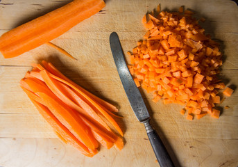 Geschnittene M&ouml;hren mit einem Messer auf einem Holzbrett