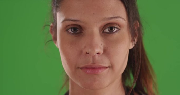 Tight shot of attractive caucasian female model looking at camera on greenscreen