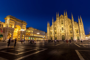 Fototapeta na wymiar MILAN, ITALY - APRIL 28th, 2018: turists during blue hour taking pictures in Duomo Square , the main landmark of the city.