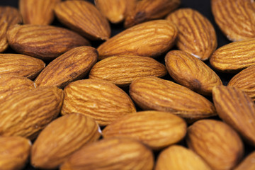 Almond pile closeup. Almond photo background. Organic food rustic banner template. Tasty healthy snack.