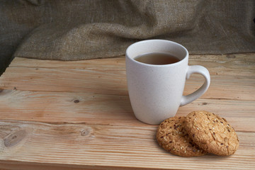 homemade oat cookies with sunflower seeds in basket and cup of tea