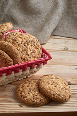 homemade oat cookies with sunflower seeds in basket on wooden table