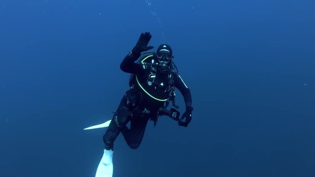 Male scuba diver swims in the blue water - Indian Ocean, Maldives
