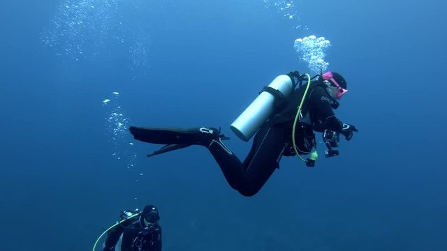 Male scuba diver swims the blue water - Indian Ocean, Maldives
