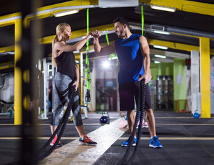 sports couple doing battle ropes crossfitness exercise