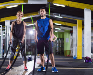 Fototapeta na wymiar sports couple doing battle ropes crossfitness exercise