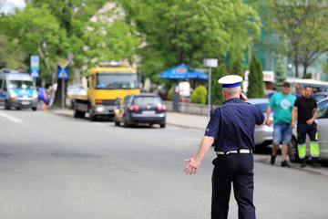 Policjant ruchu drogowego rozmawia przez telefon w czasie akcji ratunkowej w mieście Opolu.