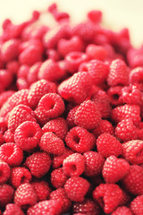 Ripe raspberries macro. Selective focus. Fruit background with copy space. Sunny summer and berries harvest concept. Sunlight effect. Vegan, vegetarian, raw food.