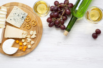 Fototapeta na wymiar Tasting cheese with wine, garpes, walnuts and pretzels on wooden background. Food for romantic. From above. Top view. Flat lay.