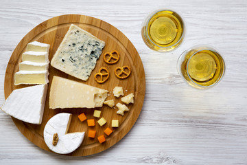 Tasting cheese with wine, walnuts and pretzels on wooden background. Food for romantic. From above. Top view. Flat lay.