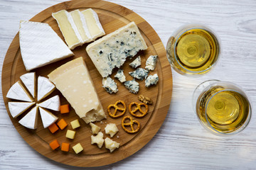 Tasting cheese with wine, walnuts and pretzels on wooden background. Food for romantic. From above. Top view.