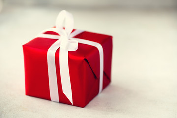 Red gift box on grey concrete background, copy space. Christmas, new year, birthday party, valentine's day, mother's and woman day concept. Present with love. Banner