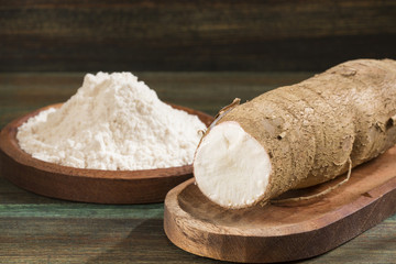 Cassava and flour on the wooden background - Manihot esculenta