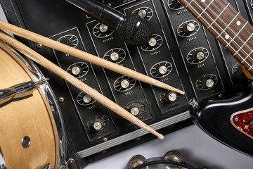 a group of musical instruments including an electric guitar, drum, cymbal, and amplifier