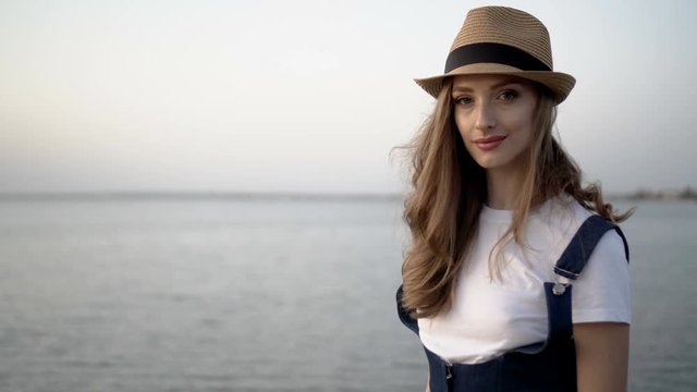 Attractive woman in a hat. Sunset
