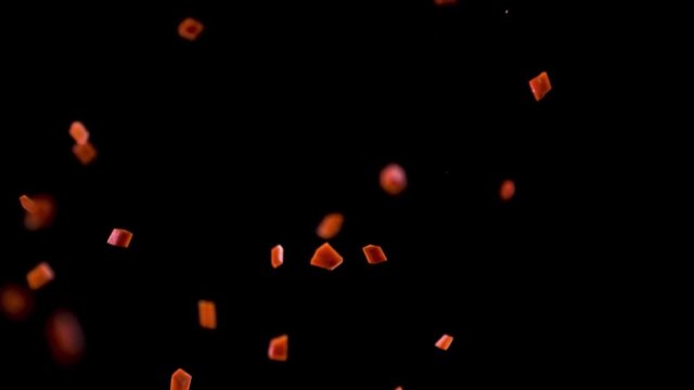 Cubes of carrots fall down in the air.