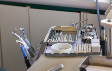 Dental instruments on silver tray including calculus plaque remover, tooth scraper and mirror set at clinic. Medical care concept