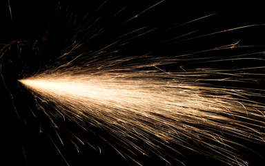 sparks from red-hot metal, bokeh warm tones, flashes in the dark