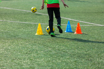 Obraz premium boys football players practice dribbling, kickson soccer training on the field in the summer
