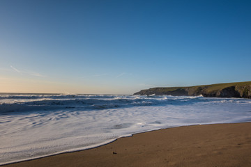 Fototapeta na wymiar Foamy Waves at a sandy beach