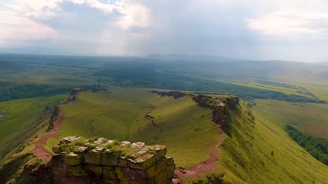 Aerial view of the mountain range Sunduki, green fields sky before the storm in the Republic of Khakassia. Russia