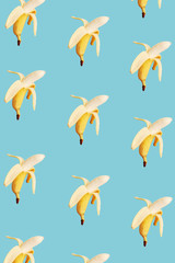 Half peeled bananas. Pattern on a blue background.
