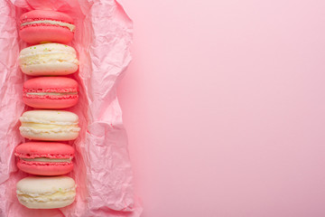 Macaroons in a box on a light pink background, flatlays, with an empty space for writing on a postcard or congratulations