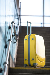 closeup shot of yellow wheeled bag on stairs at subway