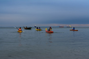 Naklejka premium Los jóvenes se acercan a la lancha con sus kayaks.