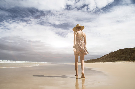 Woman walking on a tropical beach at summertime. Inspirational, people and nature concept