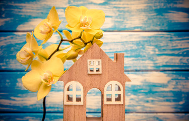 The symbol of the house and yellow Orchid on a blue background 