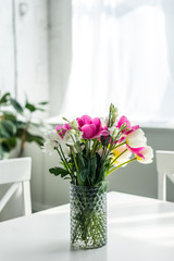 bouquet of beautiful colored flowers on white tabletop at kitchen