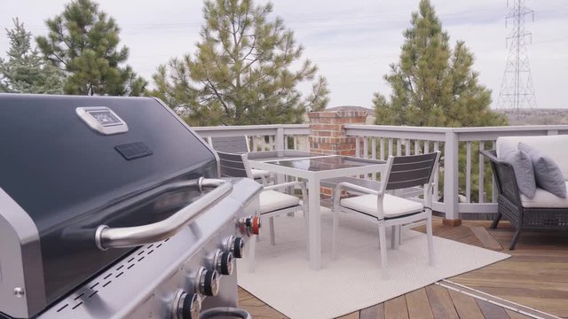 Six burner outdoor gas grill with open lid on back patio