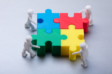 Human Figures Solving Jigsaw Puzzle