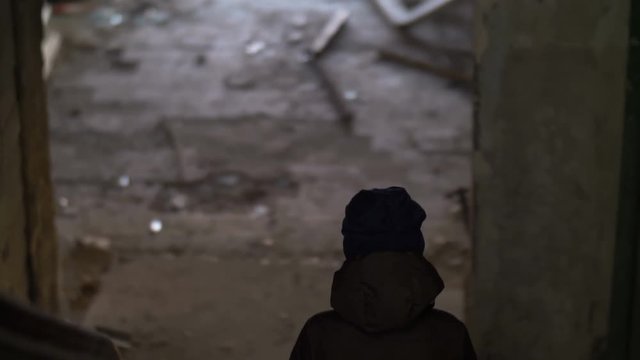 wandering boy boy walking on the abandoned building, house for demolition