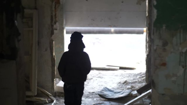 boy walks in a ruined house after a disaster, demolition old ramshackle building