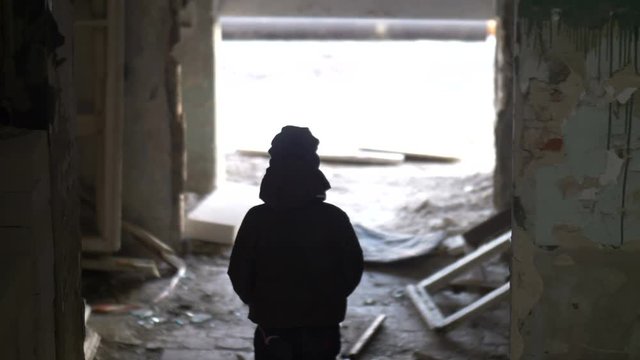 boy is walking in an old ruined house, demolition old ramshackle building