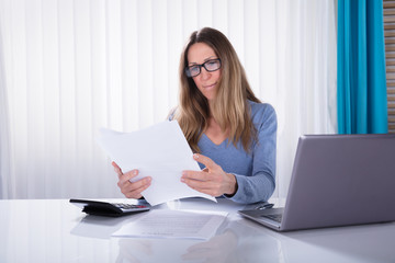 Businesswoman Reading Document In Office