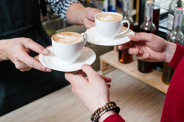 coffee bar service. client taking two cups of fresh hot tasty cappuccino