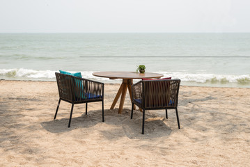 empty wooden table with two chairs at beach restaurant