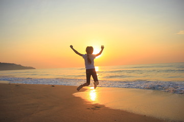Fototapeta na wymiar flying jump beach child girl on the beach in summer holiday, on sunset time.Happy little girl on the beach.soft focus