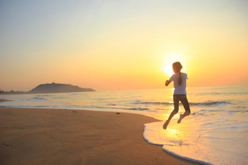 Fototapeta na wymiar flying jump beach child girl on the beach in summer holiday, on sunset time.Happy little girl on the beach.soft focus