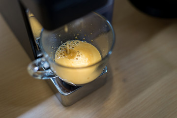 espresso machine with hot coffee in glass for refreshment