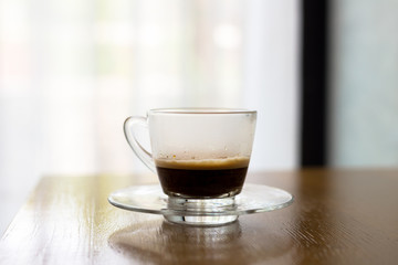 Black coffee in glass on wooden tabil for refreshment on the morning