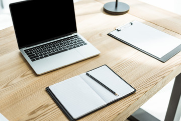 close-up shot of modern workplace with laptop and blank papers at office